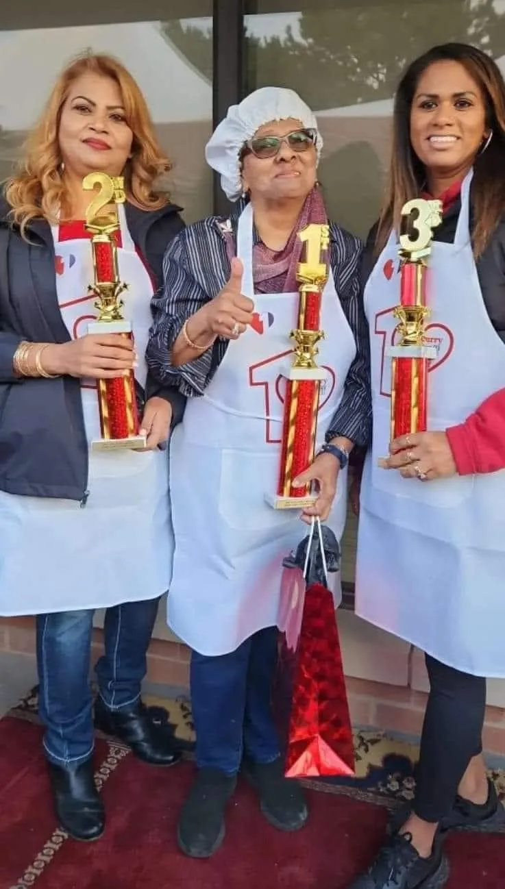 Duck Curry competition winners holding their trophies: Bibi Husain, Jamila Habib, and Sue Ann Baksh Morray