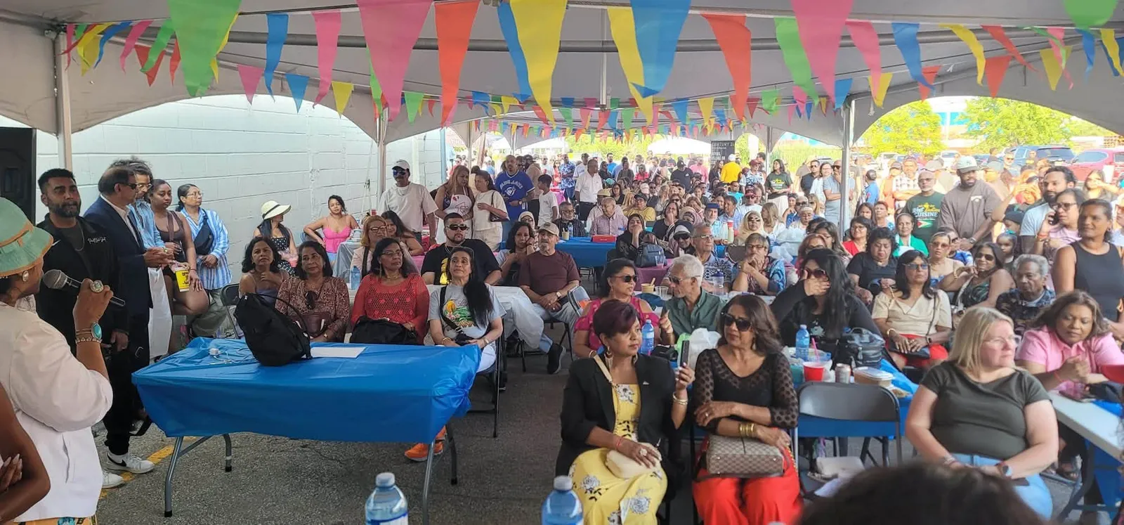 A packed tent of guests seated under colourful bunting at the fundraiser