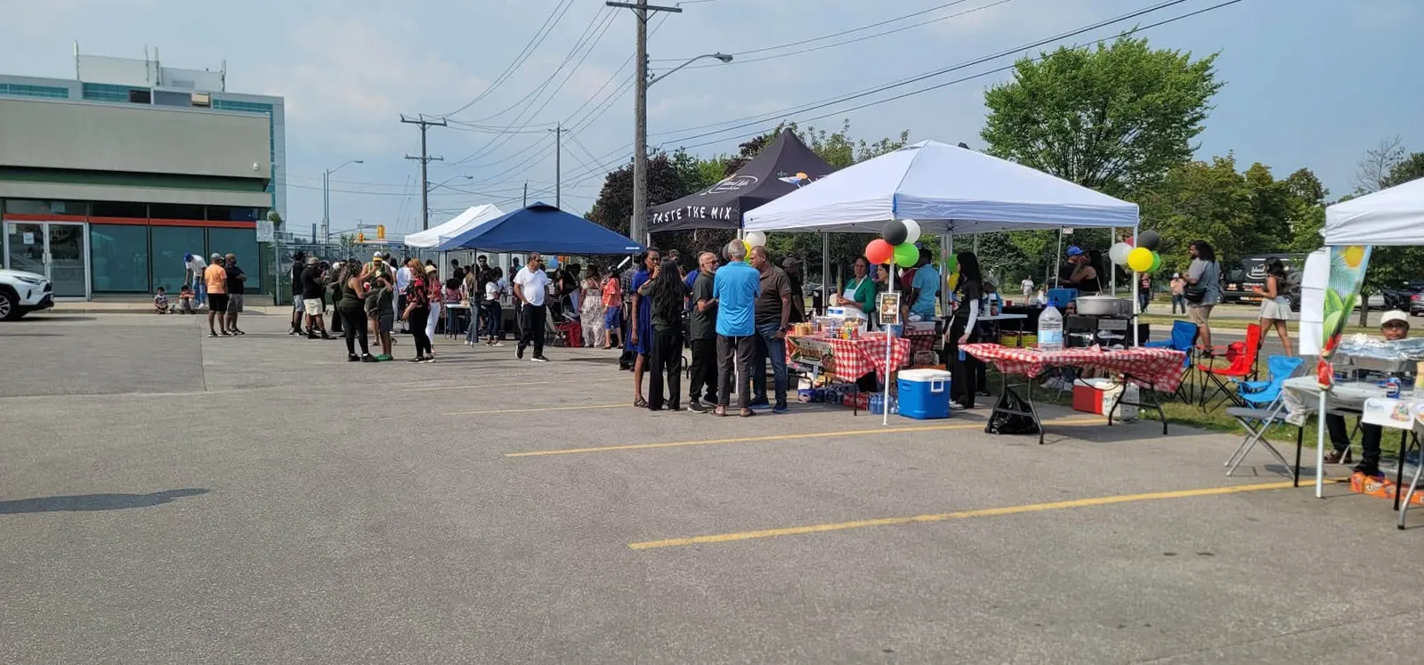 Tents, tables, and guests filling the parking lot at the One Love Duck Curry Festival