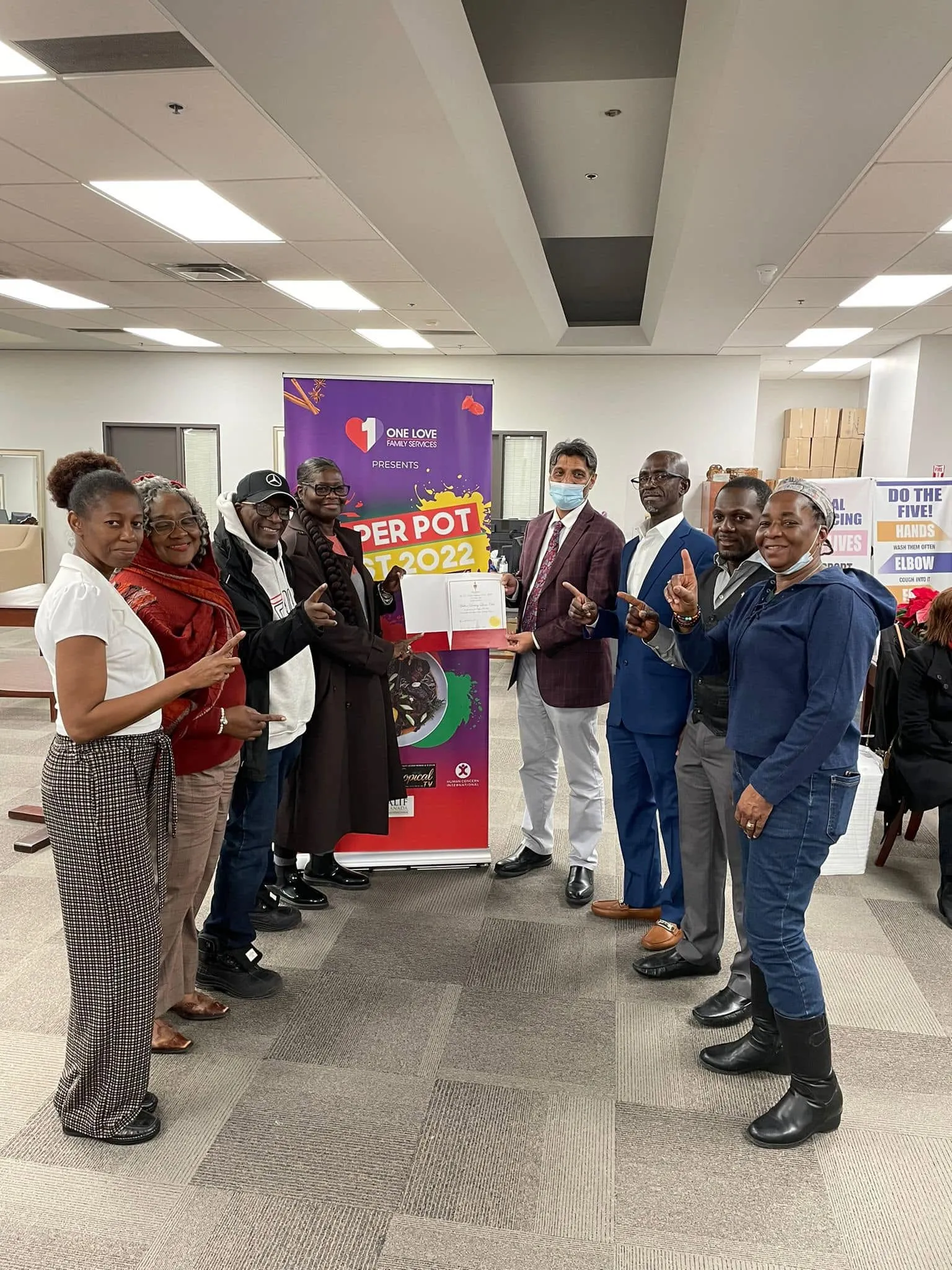 Guests and organizers gathered in front of the Pepperpot Fest banner